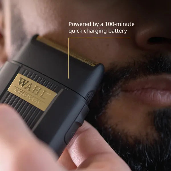 Lifestyle shot of the Wahl Micro Power shaver showcasing its 100-minute quick-charge battery while trimming a beard—ideal finishing tool for barbers searching for fast, cordless performance.