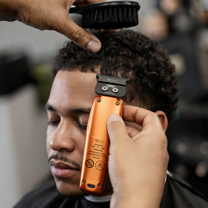 Barber using StyleCraft Saber SC421O orange trimmer on a client
